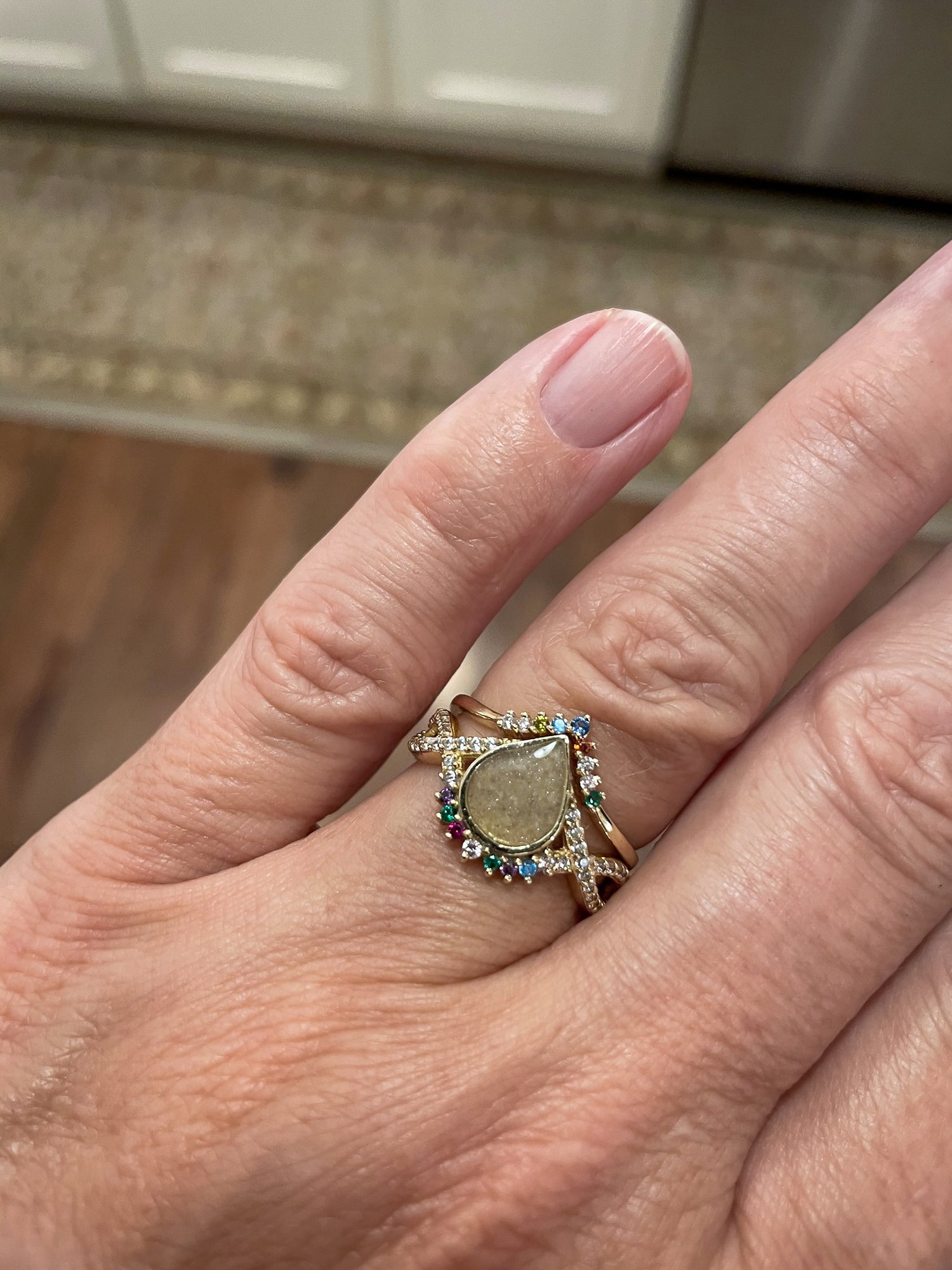 Ash Jewelry Ring on a hand of a woman with ash inclusions studded with birthstones and diamonds on the band and stacker