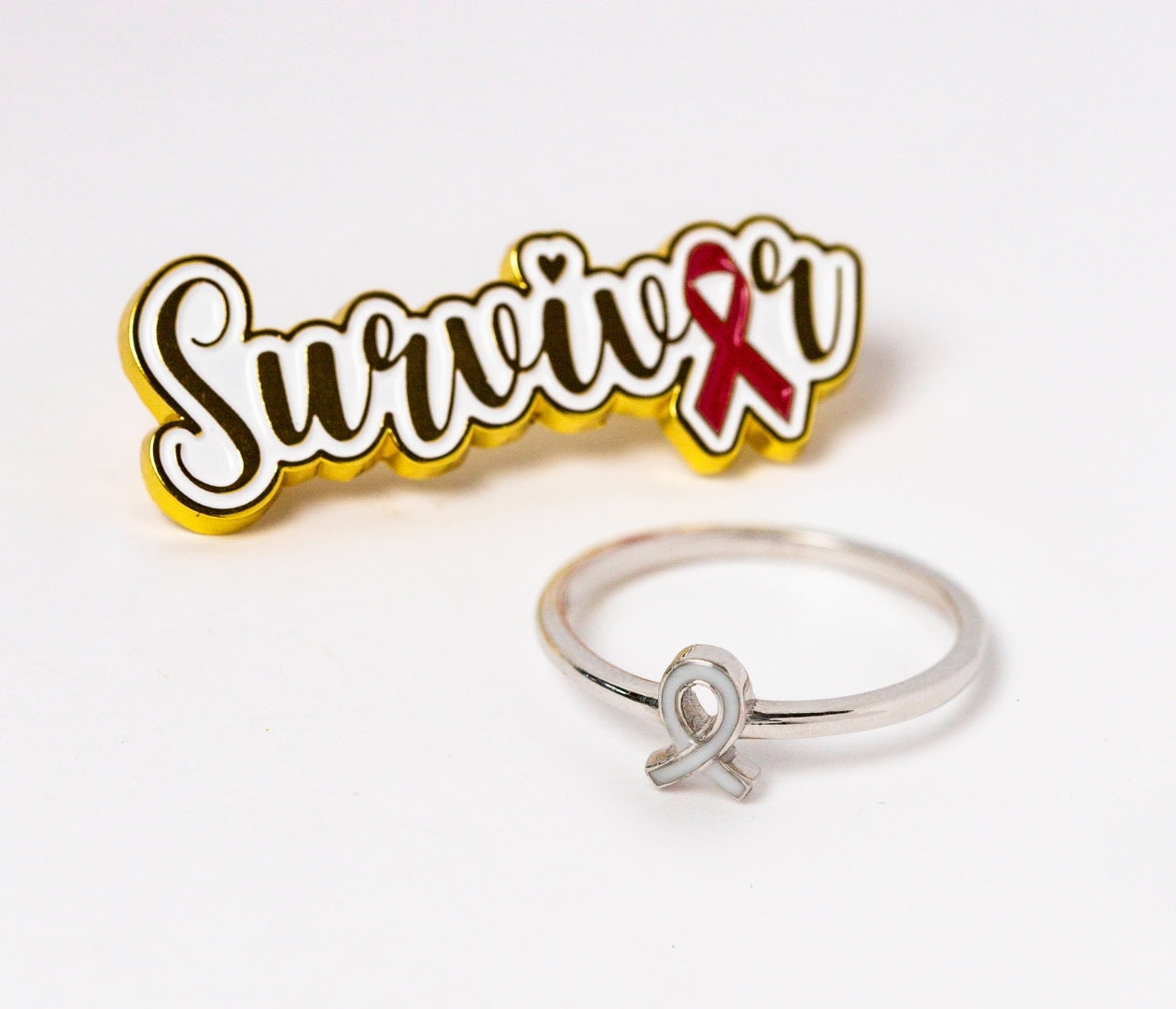 Breast Cancer Warrior ring beside gold and red Survivor pin — symbolizing hope, courage, and healing through breastmilk jewelry by Mamma’s Liquid Love ♡