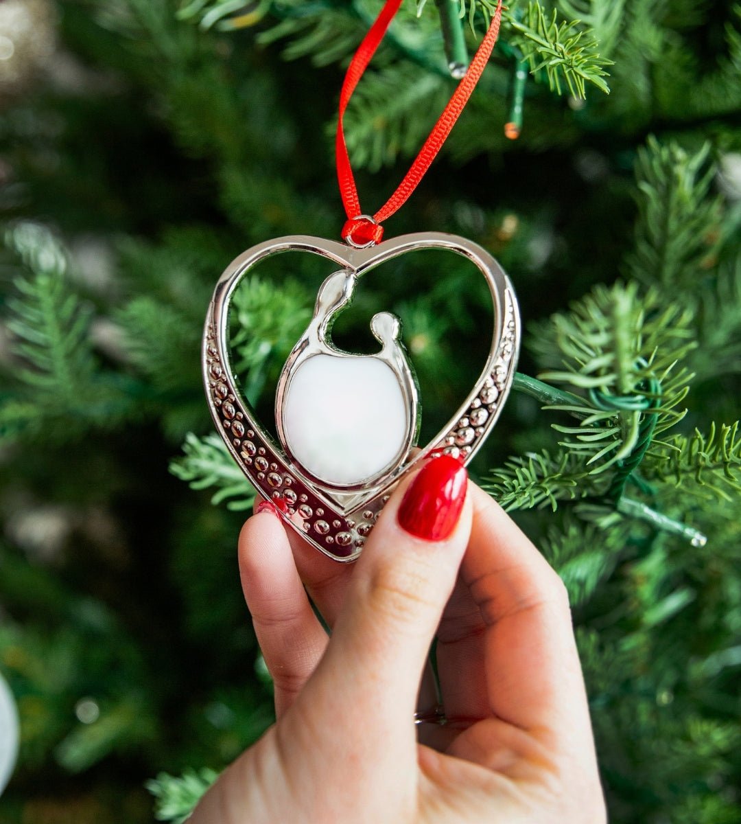 Unbreakable Bond Breastmilk Keepsake Ornament by Mamma’s Liquid Love hanging on a Christmas tree.