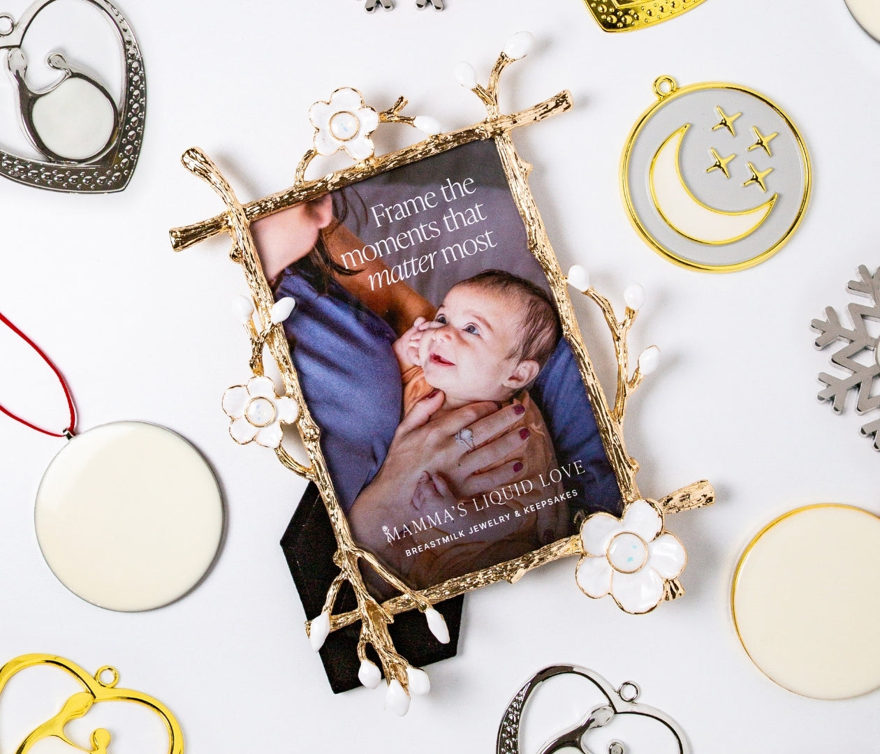 Gold floral Keepsake Frame holding a photo of a mother and baby surrounded by breastmilk ornaments — Mamma’s Liquid Love Ultimate Keepsake Bundle.