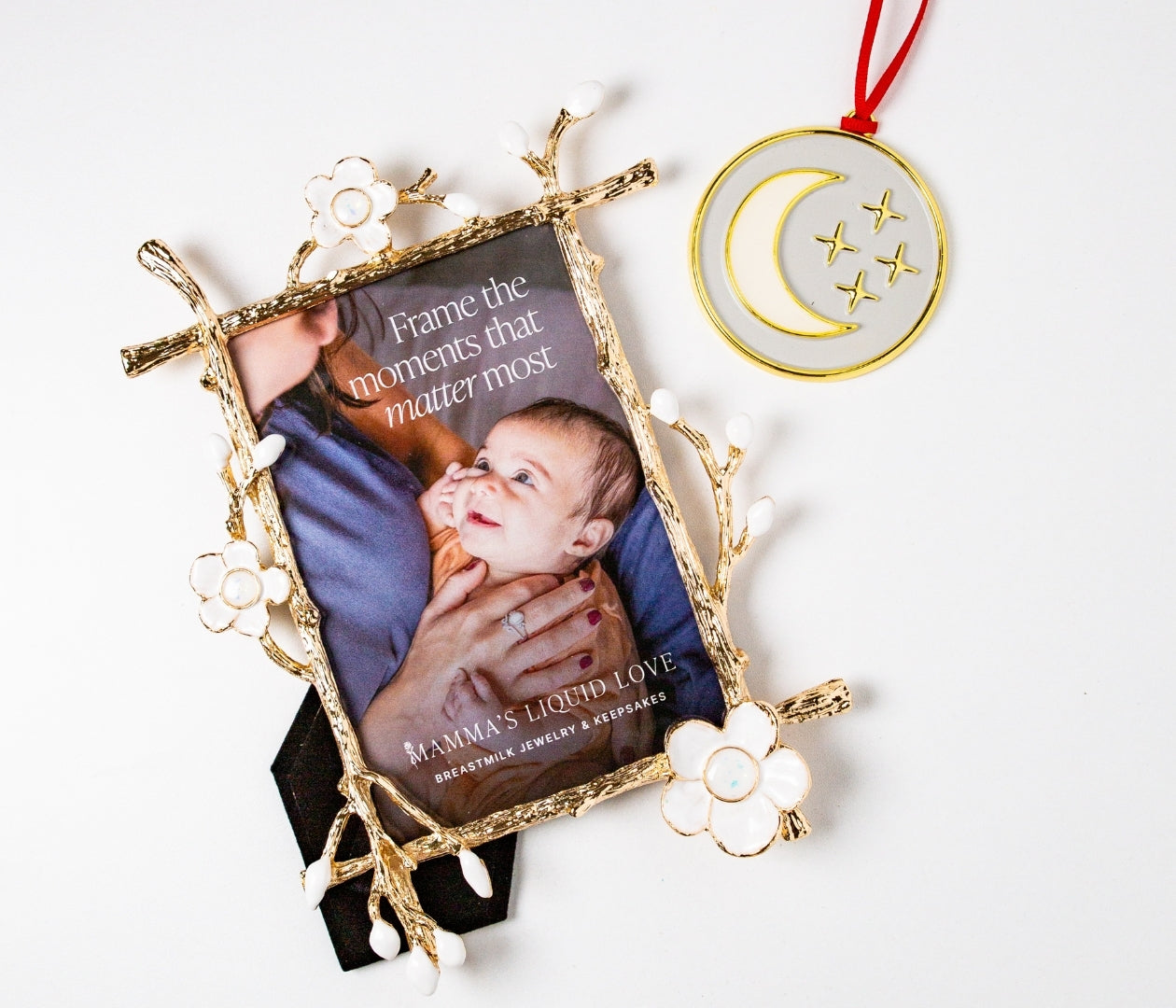 Gold floral Keepsake Frame with photo of mother and baby beside a gold moon breastmilk ornament — Mamma’s Liquid Love Keepsake Bundle.