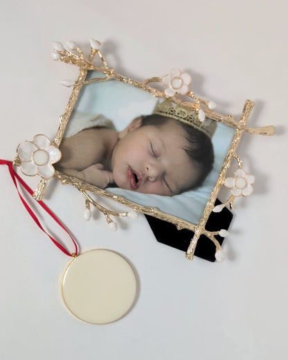 Gold floral frame from Mamma’s Liquid Love with a baby photo beside a round breastmilk keepsake ornament on a red ribbon.